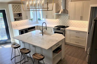 Eat-in kitchen - large contemporary l-shaped vinyl floor and brown floor eat-in kitchen idea in Calgary with a farmhouse sink, shaker cabinets, white cabinets, granite countertops, white backsplash, ceramic backsplash, stainless steel appliances, an island and white countertops