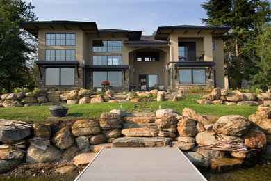 Large trendy beige two-story mixed siding house exterior photo in Other with a shingle roof