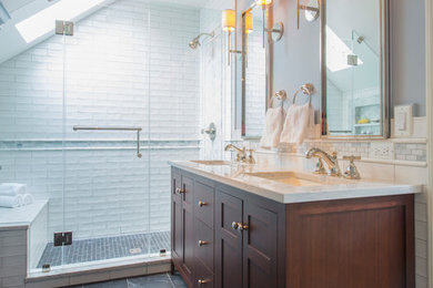 This is an example of a small transitional master bathroom in DC Metro with shaker cabinets, dark wood cabinets, an alcove shower, a one-piece toilet, white tile, marble, grey walls, ceramic floors, an undermount sink, engineered quartz benchtops, black floor, a hinged shower door and white benchtops.