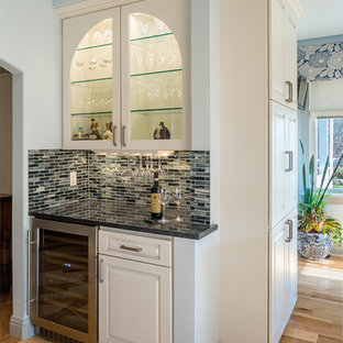 Large transitional kitchen pantry ideas - Inspiration for a large transitional l-shaped medium tone wood floor kitchen pantry remodel in Providence with an undermount sink, recessed-panel cabinets, granite countertops, blue backsplash, glass tile backsplash, paneled appliances and two islands