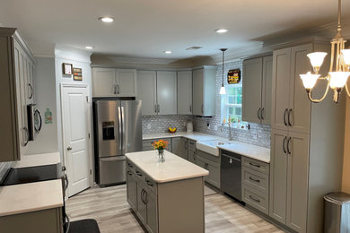 Inspiration for a mid-sized transitional l-shaped kitchen pantry remodel in Charleston with shaker cabinets, gray cabinets, quartz countertops, mosaic tile backsplash and an island