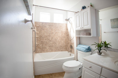 Example of a mid-sized classic 3/4 beige tile, brown tile and stone slab travertine floor bathroom design in Phoenix with raised-panel cabinets, white cabinets, a one-piece toilet, white walls, a wall-mount sink and marble countertops