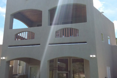 This is an example of a mid-sized southwestern concrete back porch design with a roof extension.