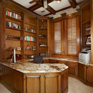 This is an example of a large traditional study room in Dallas with beige walls, limestone floors, no fireplace and a built-in desk.