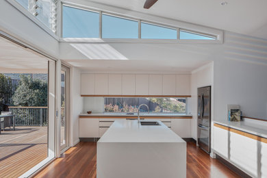 This is an example of a contemporary kitchen in Sydney with white benchtop.