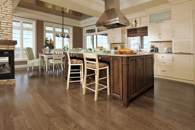Inspiration for a large contemporary l-shaped dark wood floor and brown floor open concept kitchen remodel in Cleveland with shaker cabinets, white cabinets, beige backsplash, stainless steel appliances and an island