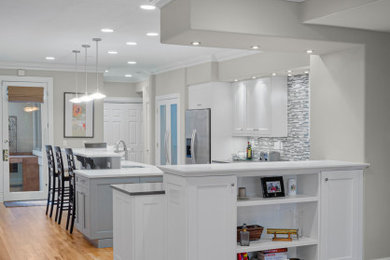 Mid-sized trendy brown floor eat-in kitchen photo in Denver with multicolored backsplash, stainless steel appliances, an island and white countertops