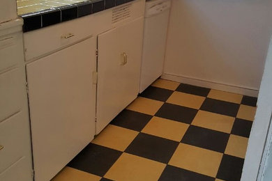 Eat-in kitchen - small ceramic tile eat-in kitchen idea in San Francisco with an undermount sink, flat-panel cabinets, white cabinets, tile countertops, yellow backsplash, ceramic backsplash and white appliances