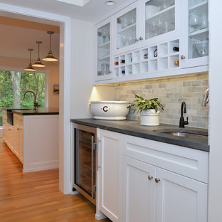 На фото: с высоким бюджетом большие параллельные кухни в современном стиле с кладовкой, белыми фасадами, полом из фанеры, островом, фасадами в стиле шейкер, врезной раковиной, столешницей из талькохлорита, фартуком из каменной плитки, разноцветным фартуком и техникой из нержавеющей стали