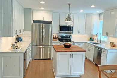 Mid-sized minimalist u-shaped dark wood floor eat-in kitchen photo in DC Metro with a single-bowl sink, shaker cabinets, white cabinets, marble countertops, white backsplash, subway tile backsplash, stainless steel appliances and an island