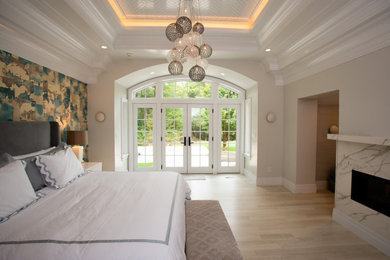 Bedroom - large transitional master light wood floor, beige floor and tray ceiling bedroom idea in Boston with white walls, a two-sided fireplace and a tile fireplace