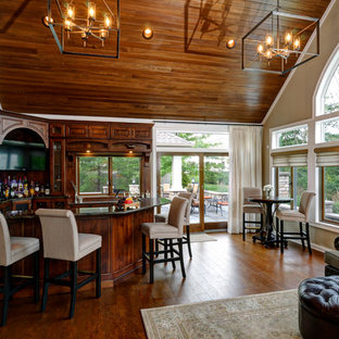 コロンバスのトラディショナルスタイルのおしゃれな着席型バー (アンダーカウンターシンク、レイズドパネル扉のキャビネット、濃色木目調キャビネット、御影石カウンター、コルクフローリング) の写真