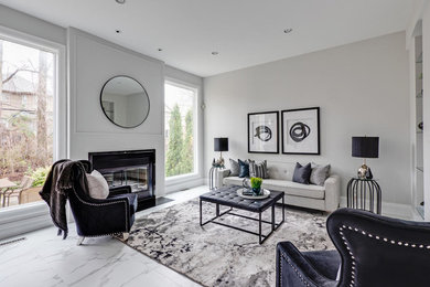Large contemporary open concept family room in Toronto with marble floors, a standard fireplace, white floor, grey walls, a tile fireplace surround and no tv.