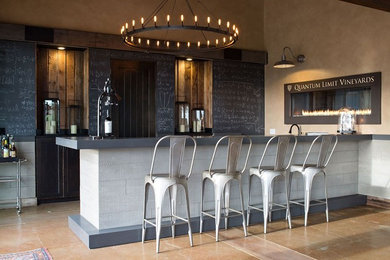 Large industrial u-shaped seated home bar in San Francisco with solid surface benchtops, multi-coloured splashback and concrete floors.