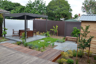 Photo of a mid-sized contemporary backyard full sun xeriscape for spring in Melbourne with natural stone pavers.