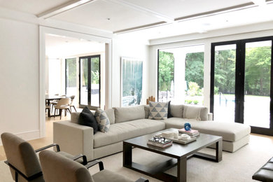 Trendy coffered ceiling family room photo in New York with white walls and a wall-mounted tv