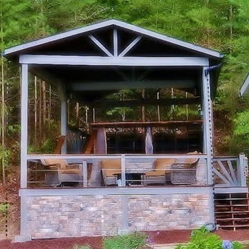 Two level deck on slope in the woods; lower level firepit area; top level bar