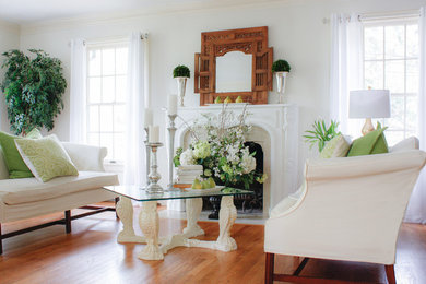 Example of a mid-sized transitional open concept medium tone wood floor and brown floor living room design in New York with white walls, a standard fireplace, a wood fireplace surround and no tv