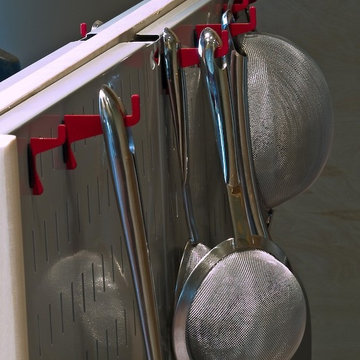Wall Control metal pegboard being used to hold some pots and pans
