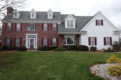 Mid-sized traditional red two-story brick gable roof idea in Milwaukee