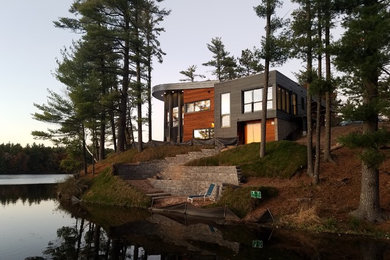 Large minimalist multicolored two-story mixed siding house exterior photo in Other with a metal roof