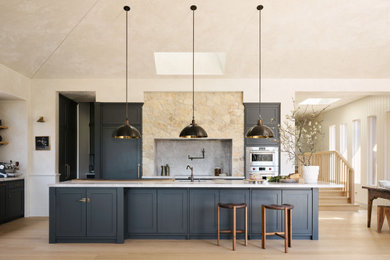 Photo of an expansive country eat-in kitchen in Sydney with an undermount sink, shaker cabinets, blue cabinets, marble benchtops, multi-coloured splashback, marble splashback, stainless steel appliances, painted wood floors, with island, brown floor and multi-coloured benchtop.
