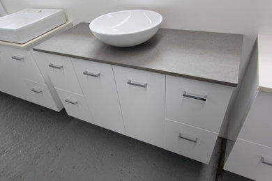 Contemporary bathroom in Melbourne with a vessel sink and white cabinets.