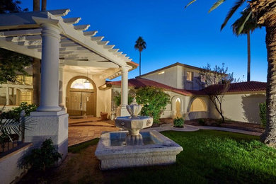 Mediterranean two-storey stucco white exterior in Phoenix with a hip roof.