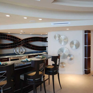 マイアミの大きいトランジショナルスタイルのおしゃれな着席型バー (アンダーカウンターシンク、フラットパネル扉のキャビネット、濃色木目調キャビネット、御影石カウンター、ライムストーンの床) の写真