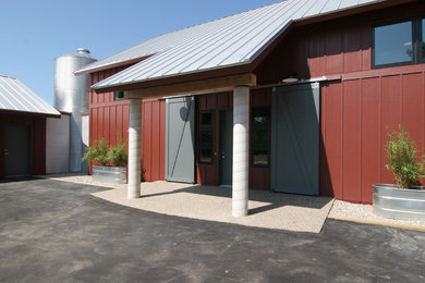 Photo of a mid-sized country two-storey red exterior in Grand Rapids with concrete fiberboard siding.