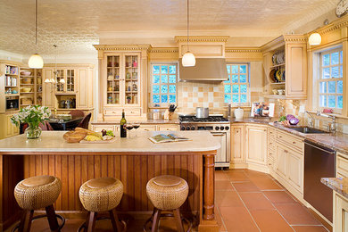 Eat-in kitchen - large transitional l-shaped terra-cotta tile eat-in kitchen idea in New York with an undermount sink, distressed cabinets, beige backsplash, stainless steel appliances, an island, raised-panel cabinets, granite countertops and stone tile backsplash