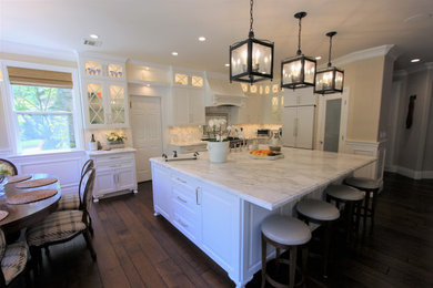 Open concept kitchen - large country l-shaped dark wood floor and brown floor open concept kitchen idea in San Francisco with a farmhouse sink, recessed-panel cabinets, white cabinets, marble countertops, white backsplash, marble backsplash, stainless steel appliances, an island and white countertops