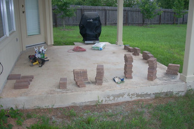 Patio - mid-sized backyard brick patio idea in Austin with a roof extension