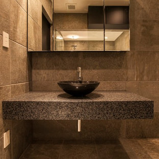 Esempio di una stanza da bagno moderna con piastrelle grigie, pareti grigie, top in granito, pavimento marrone e top grigio
