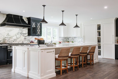 Inspiration for a large modern brown floor eat-in kitchen remodel in New York with a farmhouse sink, raised-panel cabinets, white cabinets, quartz countertops, multicolored backsplash, marble backsplash, paneled appliances, an island and white countertops