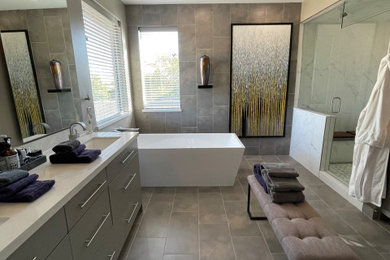 Example of a large trendy master black and white tile and porcelain tile porcelain tile, gray floor, double-sink and wainscoting bathroom design in Phoenix with flat-panel cabinets, gray cabinets, a two-piece toilet, gray walls, an undermount sink, quartz countertops, a hinged shower door, white countertops, a niche and a built-in vanity