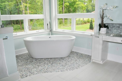 Example of a large transitional master beige tile and pebble tile pebble tile floor and multicolored floor bathroom design in Wilmington with recessed-panel cabinets, gray cabinets, a one-piece toilet, blue walls and an undermount sink