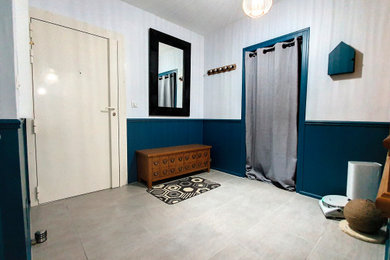 Aménagement d'un petit hall d'entrée contemporain avec un mur bleu, un sol en carrelage de céramique et un sol gris.