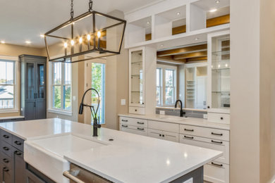 Example of a cottage l-shaped medium tone wood floor eat-in kitchen design in Cedar Rapids with a farmhouse sink, recessed-panel cabinets, white cabinets, quartz countertops, blue backsplash, porcelain backsplash, stainless steel appliances, an island and white countertops