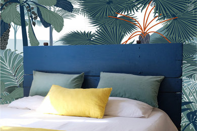 Diseño de dormitorio principal exótico grande con paredes azules, suelo laminado y papel pintado