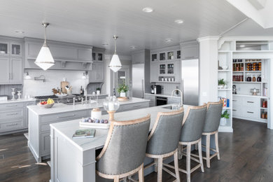 Example of a huge transitional u-shaped shiplap ceiling, medium tone wood floor and brown floor kitchen pantry design in Grand Rapids with gray cabinets, quartzite countertops, gray backsplash, limestone backsplash, stainless steel appliances, two islands, white countertops, a farmhouse sink and recessed-panel cabinets