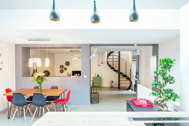 Exemple d'une très grande salle à manger ouverte sur le salon tendance avec un mur gris, un sol en carrelage de céramique et aucune cheminée.