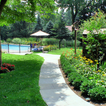 Flagstone Walkway edged with boxwoods, leading to Swimming Pool with perennials