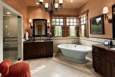 This is an example of a large arts and crafts master bathroom in Salt Lake City with raised-panel cabinets, dark wood cabinets, a freestanding tub, an open shower, stone tile, orange walls, ceramic floors, an undermount sink, granite benchtops and beige tile.