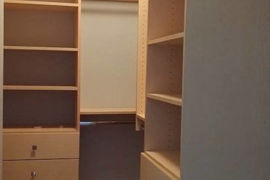 Large gender-neutral walk-in closet photo in Vancouver with flat-panel cabinets