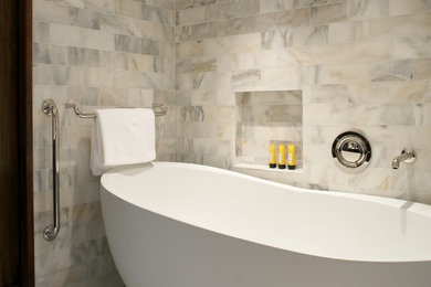 Inspiration for a transitional master white tile and stone tile mosaic tile floor freestanding bathtub remodel in Boston with marble countertops
