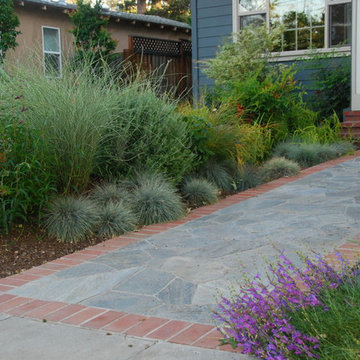 The front walk uses quartzite flagstone to complement the native garden, with br