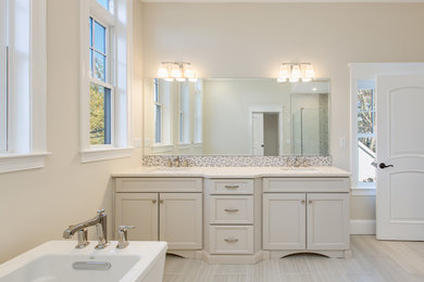 Design ideas for a large transitional master bathroom in Boston with shaker cabinets, white cabinets, a freestanding tub, a corner shower, multi-coloured tile, mosaic tile, beige walls, an undermount sink, granite benchtops, a hinged shower door and white benchtops.