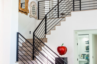 Photo of an expansive contemporary wood u-shaped staircase in Las Vegas with wood risers and metal railing.