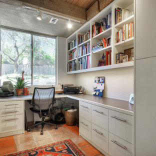 Inspiration for a small contemporary study room in Denver with white walls, a built-in desk, terra-cotta floors and no fireplace.